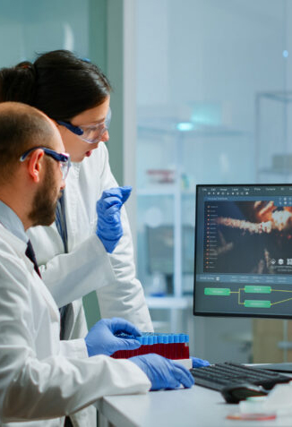 Team medical scientist conducting DNA experiments looking in computer
